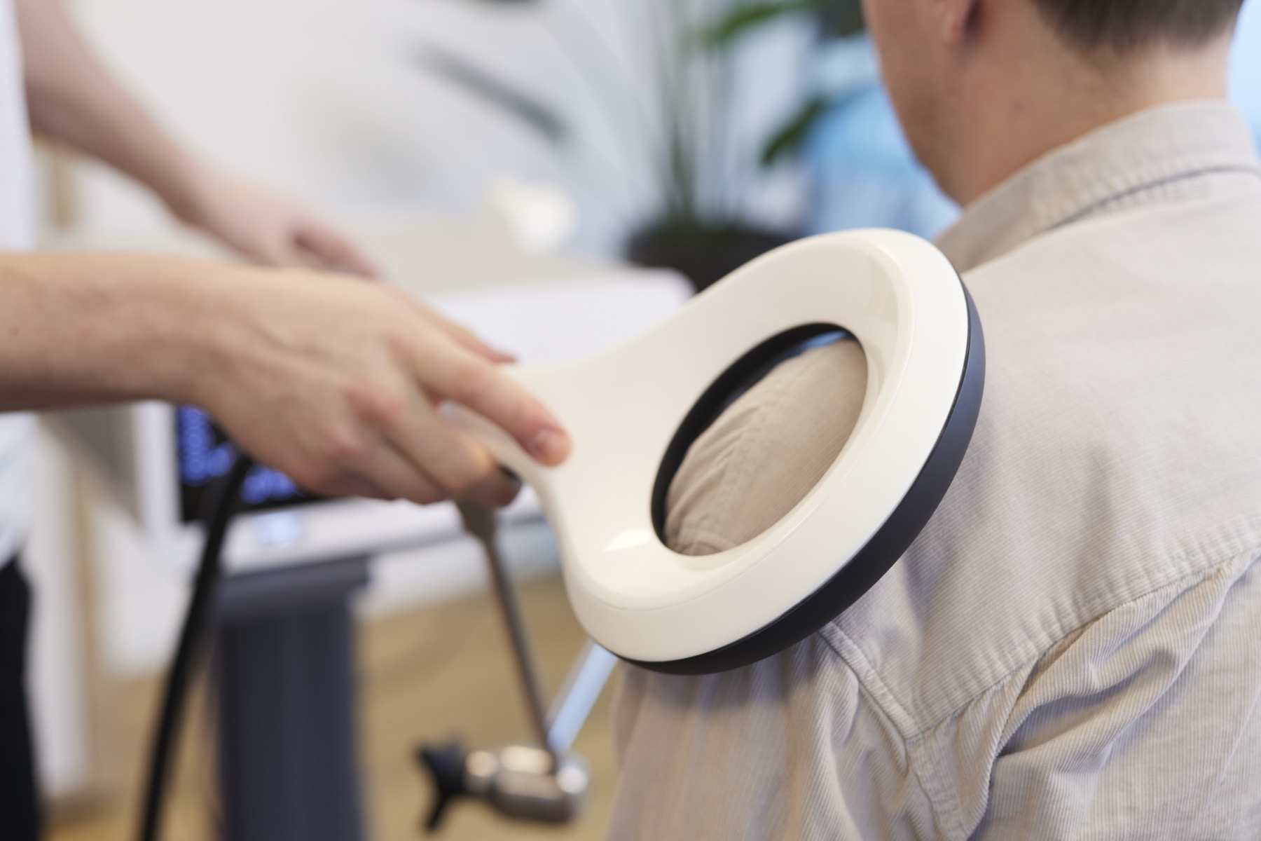 Eigen praktijkfoto van EMTT bij de schouder, met de magneetapplicator boven kleding